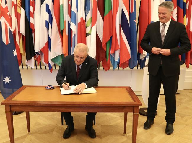 Scott Morrison signs the guest book at the OECD as Mathias Cormann looks on. Picture: Adam Taylor/PMO