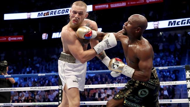 Floyd Mayweather Jr lands a blow on Conor McGregor. Picture: Getty Images