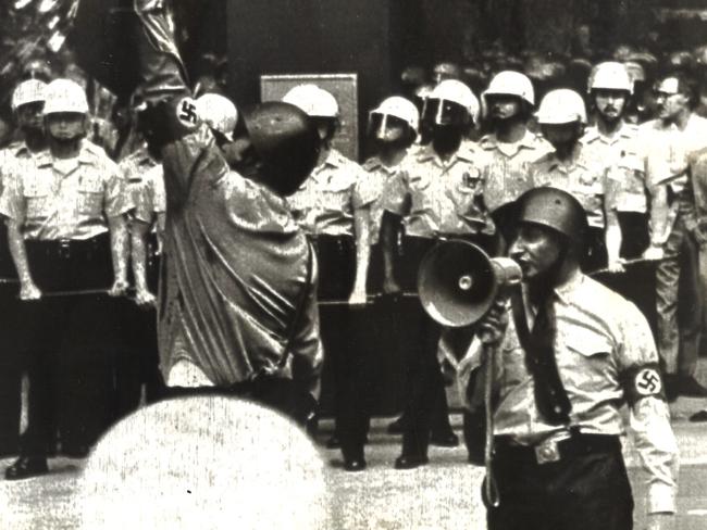 Nazi leader Frank Collin speaks on a bullhorn in Chicago while a supporter holds a shield on which an egg thrown by a protester breaks. Picture: UPI