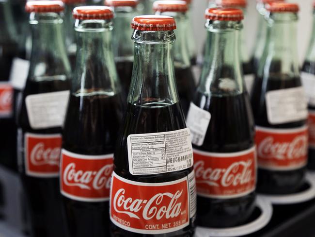 In this July 9, 2015 photo, bottles of Coca-Cola are on display at a Haverhill, Mass. supermarket. Coca-Cola reports quarterly financial results on Wednesday, July 22, 2015.(AP Photo/Elise Amendola)