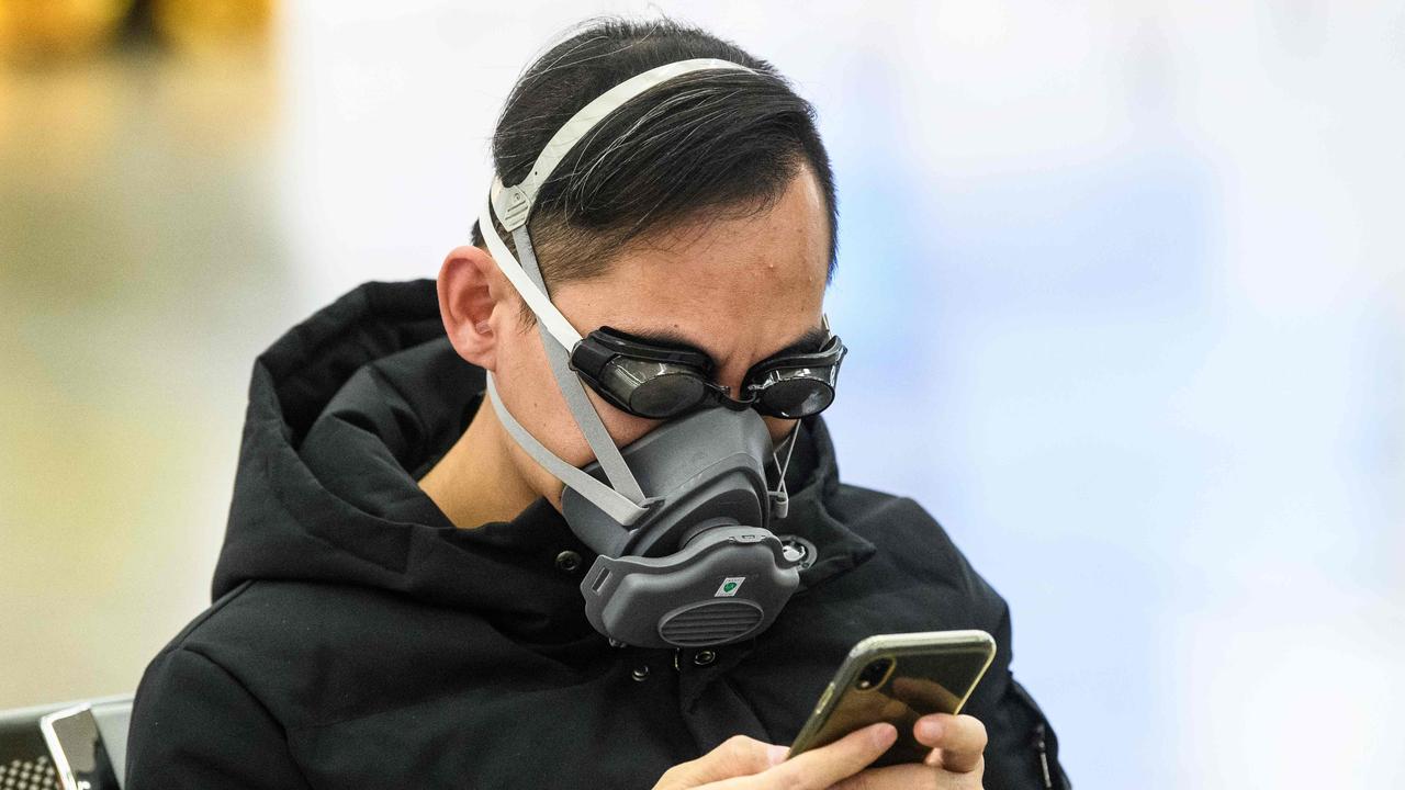 A passenger wears swimming goggles and a face mask as he waits inside a train station in Hong Kong. Picture: AFP/Anthony WALLACE