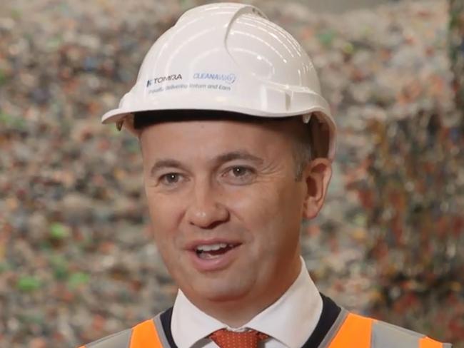 BIG EARNER: Environment minister Matt Kean talks up the return and earn scheme in front of mountains of recyclable plastic.