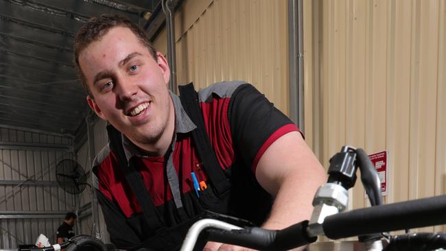 Despite only having the use of one of his arms, Pacific Pines mechanic, 23-year-old Alex Lees, who now works at Von Bibra Auto Village, has never given up on life. Picture Glenn Hampson