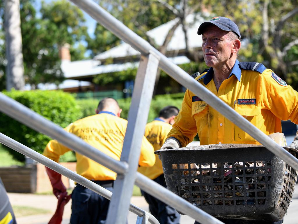 Mr Abbott helps residents clear debris from their flood damaged homes in Windsor, NSW. Photo: NCA NewsWire/Bianca De Marchi