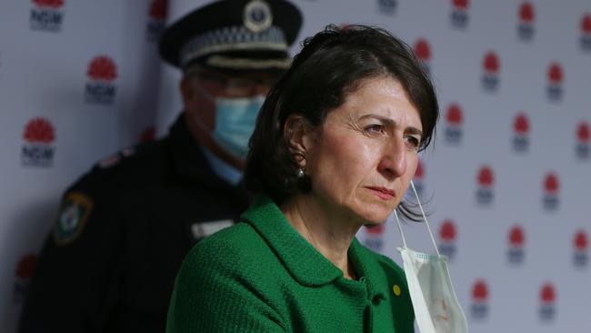 Premier Gladys Berejiklian removes a face mask during a newss conference. Picture: Getty