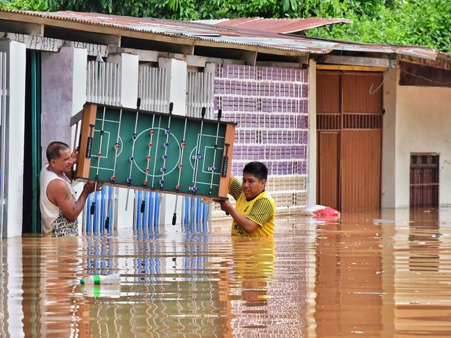 Residents salvage belongings from homes inundated by the Acre River’s surge in Cobija, Bolivia, amidst a deadly rainy season. Picture: AFP