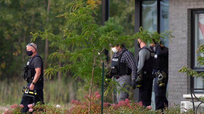 Forensic officers leave a building in Longueuil, Quebec, on Tuesday. Picture: Reuters