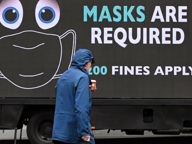 A man walks past a sign on a truck in Melbourne. Picture: AFP