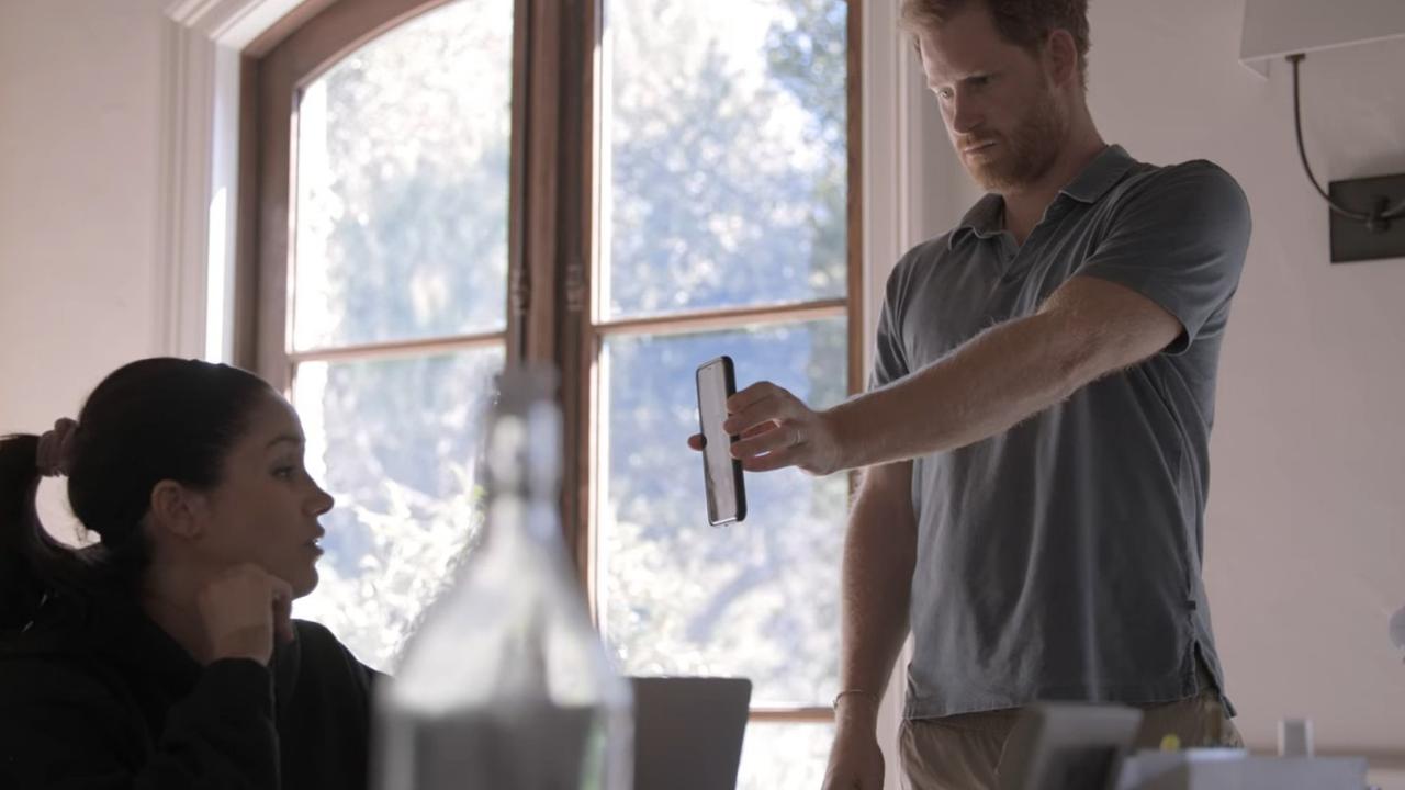 The series includes moments like this one – Harry showing Meghan a private text from William. Picture: Netflix