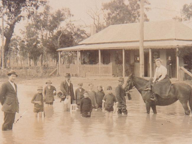 Locals outside the Bimbi Post Office during a flood in October, 1916.