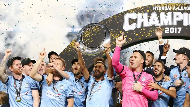 Sydney FC players celebrate with the trophy.