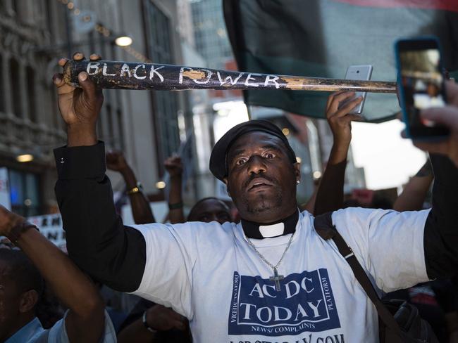 A man holds a bat reading "Black Power" at the protest that turned deadly. Picture: AFP/Laura Buckman