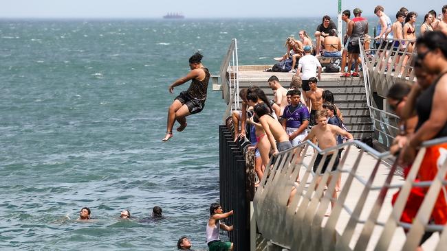 People jump off Altona Pier as the heat hits 38 degrees. Picture: Ian Currie