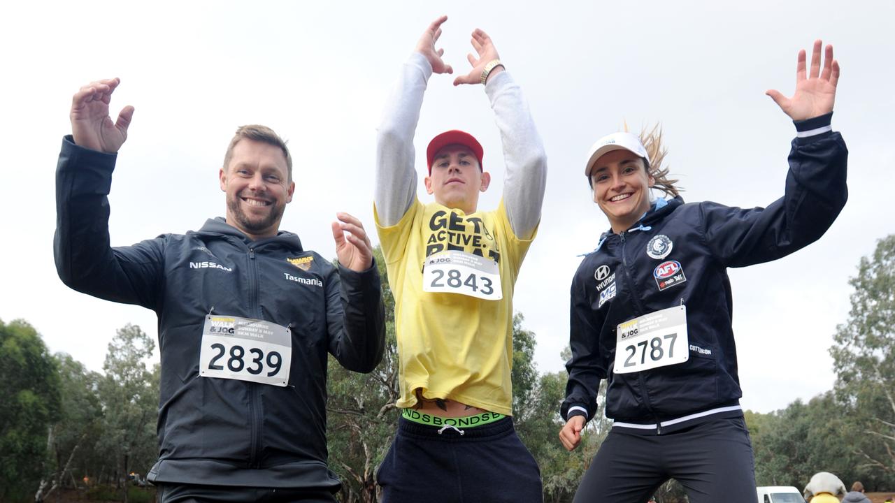 Collingwood’s Ben Crocker taking part in the Melbourne Memory Walk and Jog at Westerfolds Park, Templestowe, for Dementia Australia with Sam Mitchell and Nicola Stevens. Picture: Andrew Henshaw