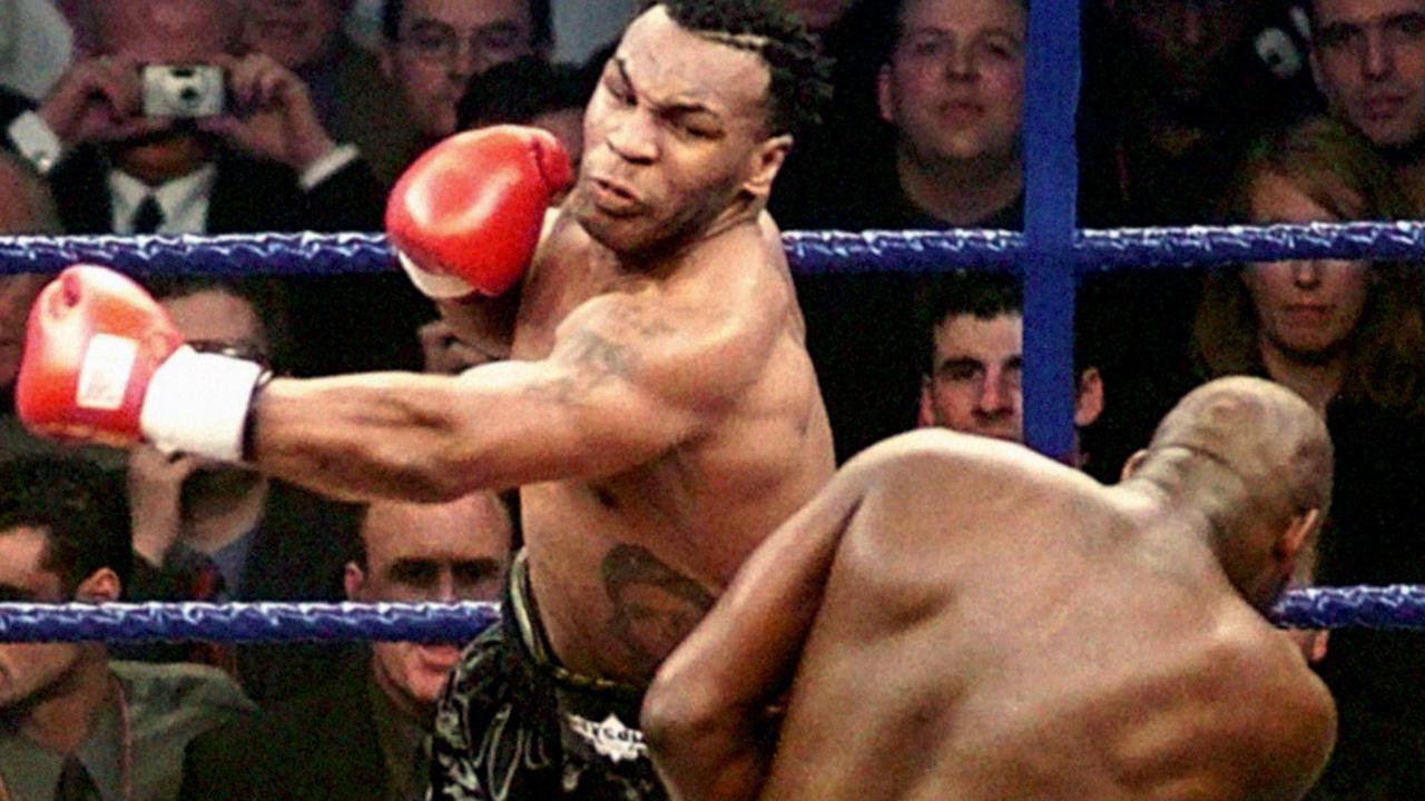 American boxer Mike Tyson throws a punch at Briton's Julius Francis. Photo by Owen Humphreys – PA Images/PA Images via Getty Images