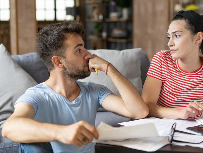 Frustrated concerned young couple calculating overspend budget, doing paperwork job at laptop, talking about financial problems, insurance, mortgage, fees, loan conditions, bankruptcy, economic inflation; money budgeting stress banking generic