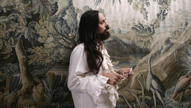 Gucci creative director Alessandro Michele in front of a tapestry at home in Rome.