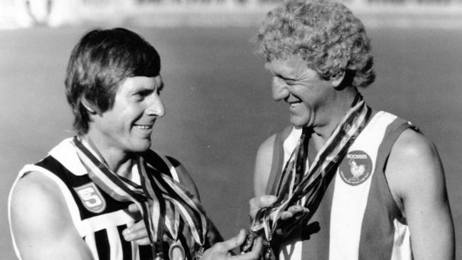 Former Port Adelaide Magpies footballer Russell Ebert and North's Barrie Robran compare their Magarey Medal collections. Picture: Neon Martin