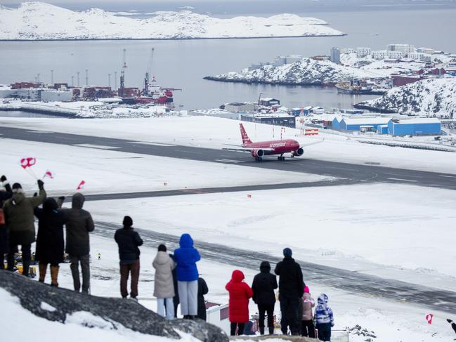 An Air Greenland flight takes off at the new airport in Nuuk, Greenland as locals brave the cold to watch. Donald Trump has said buying the territory is a “necessity”. Picture: Supplied.