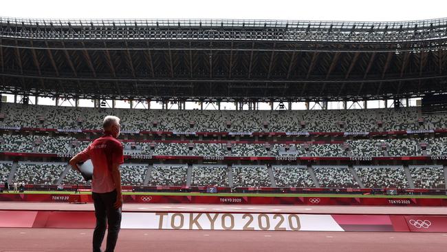 A passer-by looks on while wearing a protective face covering due to the Covid-19 pandemic inside the Olympic Stadium. Picture: Patrick Smith/Getty Images