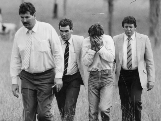 Michael Murphy (head in hands) with detectives including Ian ‘Speed’ Kennedy (left) at in the Prospect field where he murdered Anita Cobby.