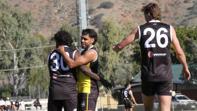 CAFL players gather around Marcus MacDonald (30) to celebrate one of the five goals he kicked against St Mary’s. Picture: Gera Kazakov