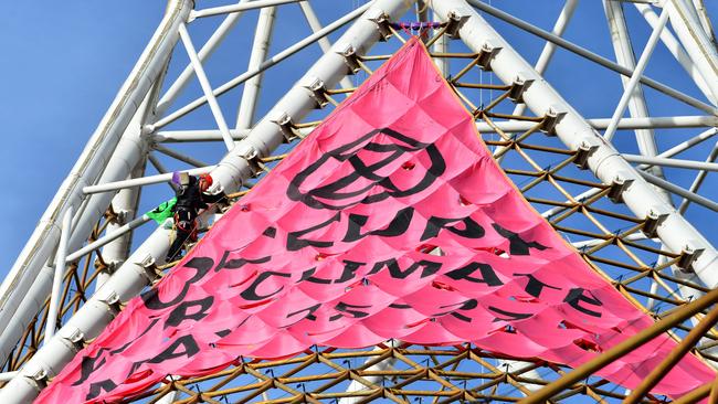 An Extinction Rebellion protester has scaled the spire at the Arts Centre. Picture: Nicki Connolly