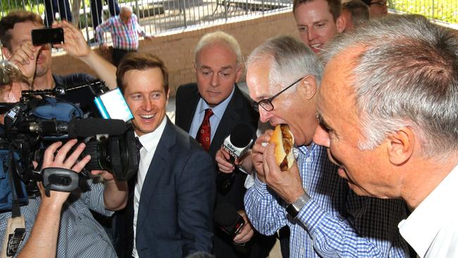 Liberal candidate for Bennelong John Alexander (right) with Prime Minister Malcolm Turnbull (eating) at Gladesville Public School. Picture: AAP/Ben Rushton