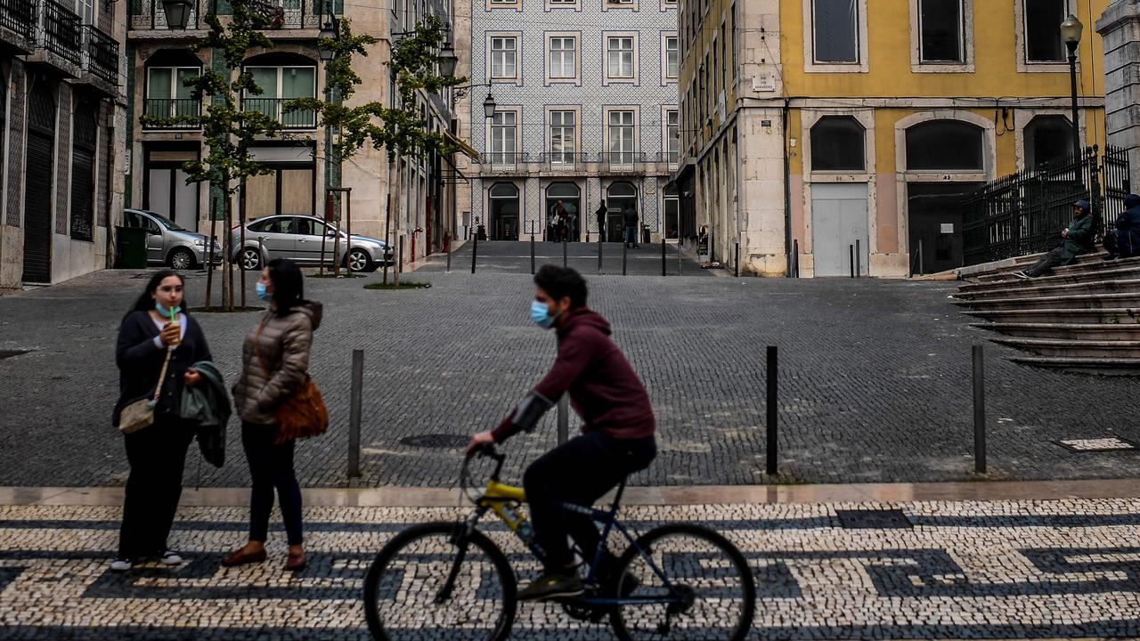 A man rides a bicycle past an empty square in downtown Lisbon. The Portuguese government at the time held an extraordinary ministers' council to decide on concrete measures to fight the spread. Picture: Patricia De Melo Moreira / AFP