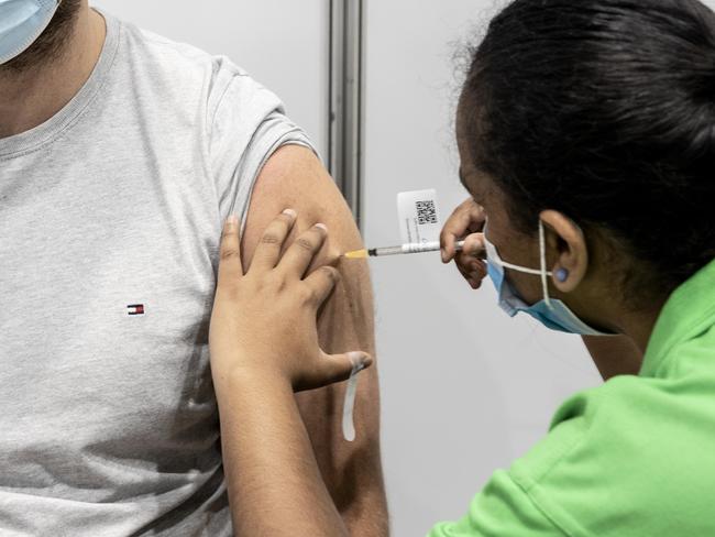 BRISBANE AUSTRALIA - NewsWire Photos NOVEMBER 1, 2021: Rhys Barnes gets a Pfizer vaccination from enrolled nurse Maria Mathews at the Brisbane Convention and Exhibition centre vaccination hub. NewsWire / Sarah Marshall