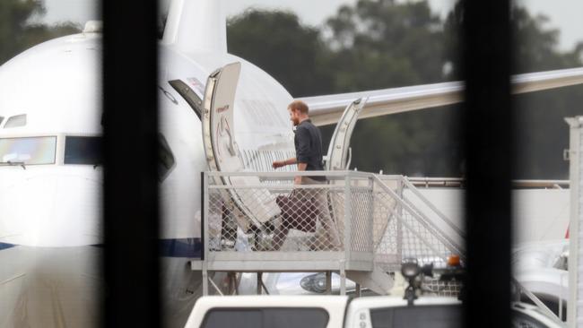 Prince Harry boarding a plane at Sydney Airport to fly to Fraser Island. Picture: David Swift.