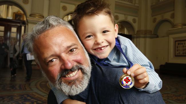 Community Hero Awards by Ambulance Victoria for those who have saved others at Parliament House. Kai Macquet 5, won a Hero Award for coming to the aid of his Dad Justin Macquet who was trapped under his ute by running to a neighbour's house to raise the alarm. Kai and Dad Justin after receiving the award medal. Picture: David Caird.