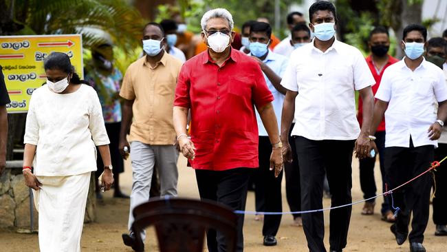 Sri Lankan President Gotabaya Rajapaksa, front, and his wife Anoma, left, leave a polling station in the capital, Colombo. Picture: AFP