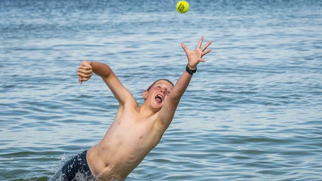 Zion Clark, 11, goes for a catch at the beach in Middle Park. Picture: Jake Nowakowski