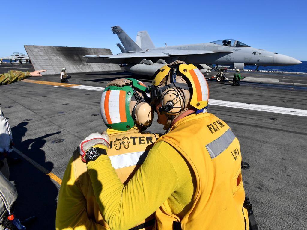 Crew are seen preparing an F/A-18F Super Hornet for take off on the USS Ronald Reagan. Picture: AAP Image/Darren England