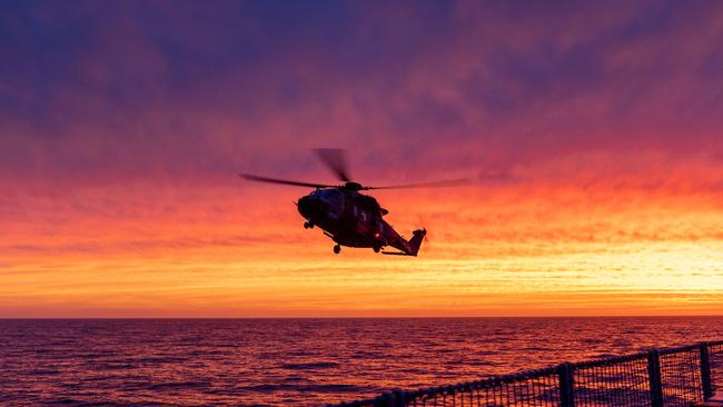 A maritime support helicopter attached to HMAS Choules makes a final approach to land during the ship’s transit along the east coast of Victoria during the bush fire emergency in January.