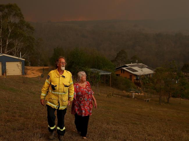 John and Karen McMahon, from Myrtle Mountain near Candelo, watch from their home as the Big Jack Mountain fire gathers intensity. Picture: Toby Zerna