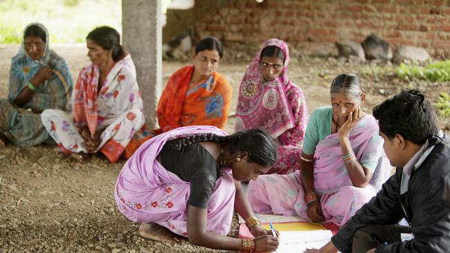 A local woman signs a register to receive a loan in Sadasivpet, India.