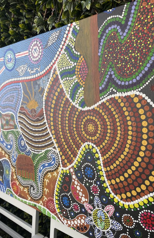 Each section is broken up by white dots. Top right is the section of man who's painted the journey of moving on from divorce. Centre is Chris Gray's dedication to Country (the earthy colours are strongly tied to the land) and in the bottom corner is a woman who's drawn a yarning circle surrounded by her children (represented with the 'U' shapes).