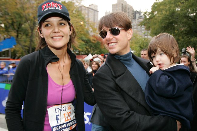 An athletic Katie Holmes joins her husband Tom Cruise as he holds their daughter Suri after she finished the New York City Marathon in 2007. Photo: AP