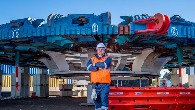 Senior project engineer Michael Cocksedge stands underneath Bella’s cutting head. The giant disc will be fitted into the front of the machine and dig at a rate of 9m per day by constantly spinning. Picture: Jake Nowakowski