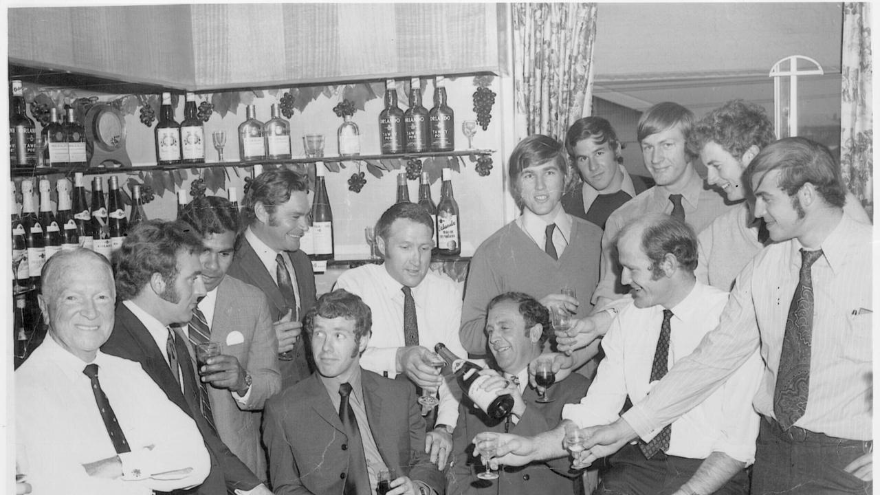 The Carlton football team celebrate the 1970 Premiership win against Collingwood with the umpires. L-R Roy McKay (from orlando the company which was sponsoring the team), Wes Loft, Syd Jackson, Ron Barassi, Adrian Gallagher (seated), John Nicholls, Don Jolley (seated), Bryan Quirk, Denis Munari, Barry Gill (seated), David McKay, Robert Walls and Alex Jesaulenko.