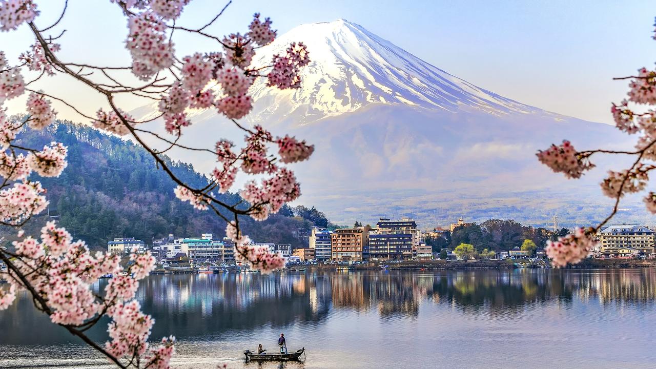 Japan’s distinctive cherry blossom, Kawaguchiko Lake and the village of Sakura with Mt Fuji Mountain in the background.
