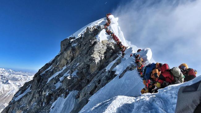 Mountain climbers line up to stand at the summit of Mount Everest on one of the busiest days on the world's highest mountain. Picture: AFP