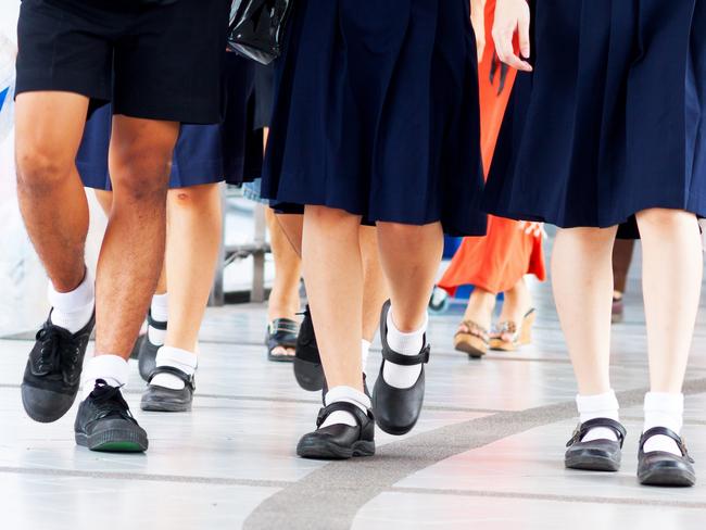 Capture of feet and shoes of students in school uniform and leaving shopping mall and walking over pedestrian bridge.