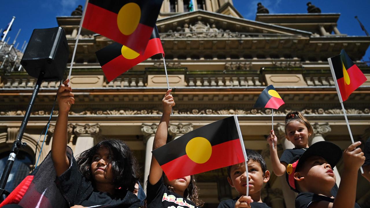 Children wave the Australian aboriginal flag as protesters take part in an "Invasion Day" demonstration on Australia Day in Sydney.