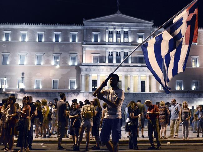 Unhappy ... a man waves a Greek flag in front of the Greek parliament in Athens, during an anti-austerity demonstration.