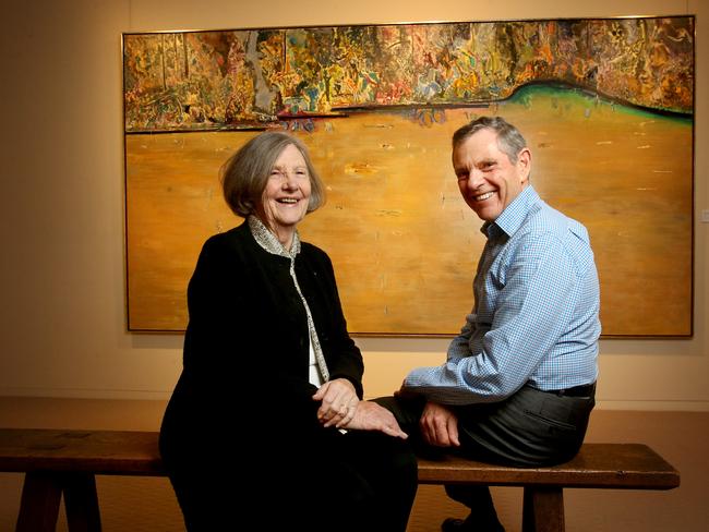 Lyn Williams, widow of the late Fred Williams, with Philip Bacon from Philip Bacon Galleries, in front of the masterpiece Forest Pond. Picture: AAP/Darren England