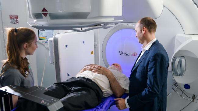 Mergers and acquisitions activity continues in healthcare despite the broader market uncertainty. Above, a GenesisCare radiation oncologist with assistant with a patient. Picture: GenesisCare