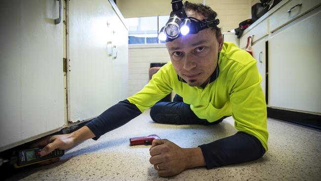 Martin Bohata, from Healthy Homes Tasmania, performs a mould test on a public housing unit in South Hobart. Picture: LUKE BOWDEN